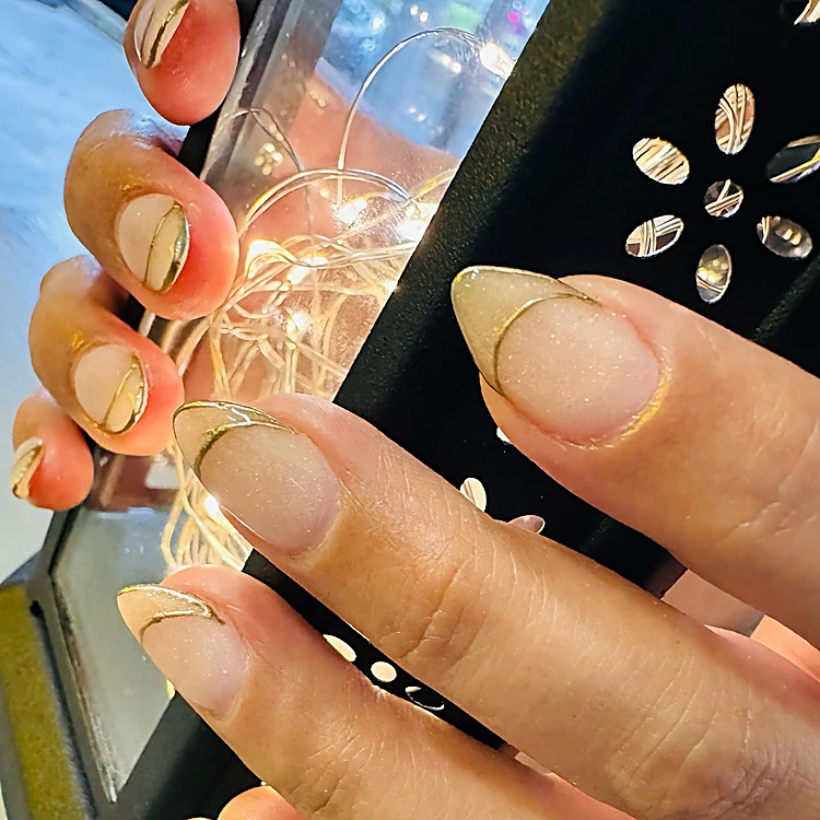 Uñas almendra en nude con francés de línea dorada
